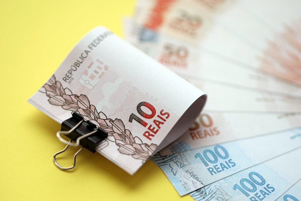 Close Up Of Brazilian Reais Money Bills In Big Amount On Yellow. Pile Of Brazil Real Currency - Abrir Empresa Simples