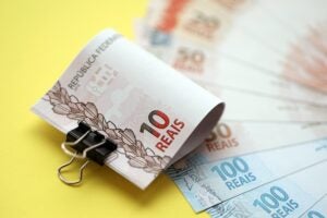 Close Up Of Brazilian Reais Money Bills In Big Amount On Yellow. Pile Of Brazil Real Currency - Abrir Empresa Simples